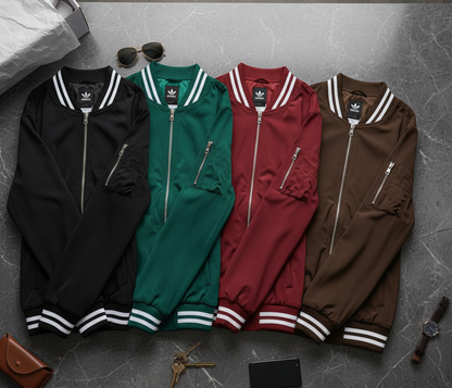 Four Adidas tracksuits in black, green, red, and brown on a gray floor.