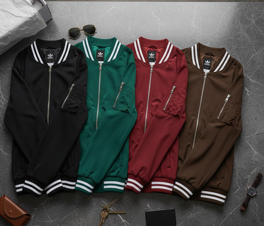 Four Adidas tracksuits in black, green, red, and brown on a gray floor.